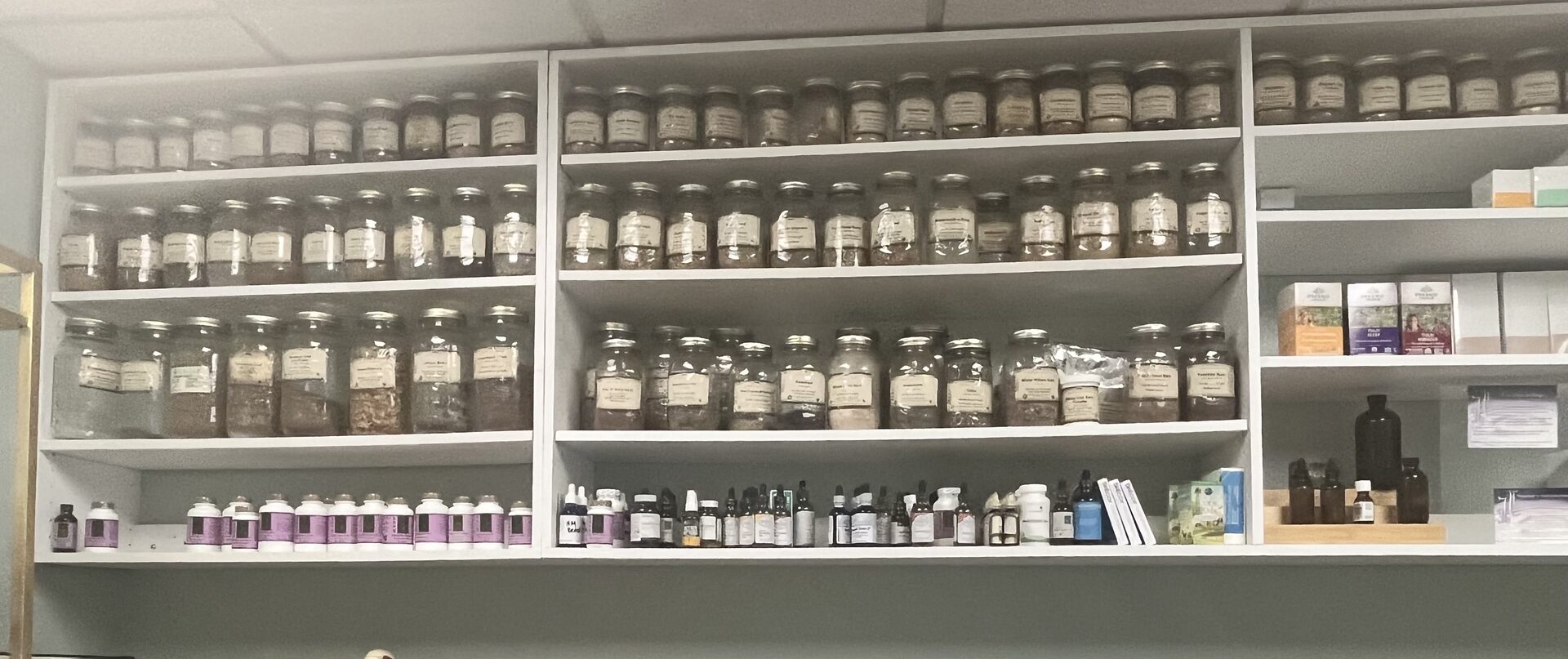 Additional shelves of single-herb jars used to build custom formulas